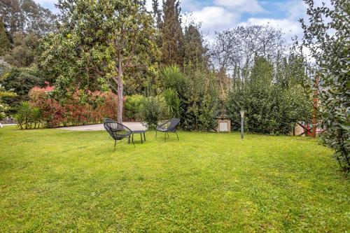 two chairs and a table in the grass at Pio Bove Rooms in Pietrasanta