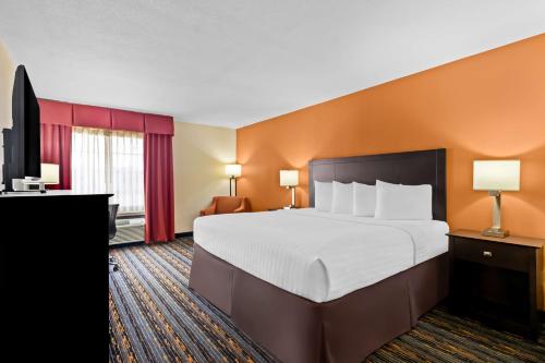 a hotel room with a large bed and a flat screen tv at Best Western Kenosha Inn in Broken Arrow