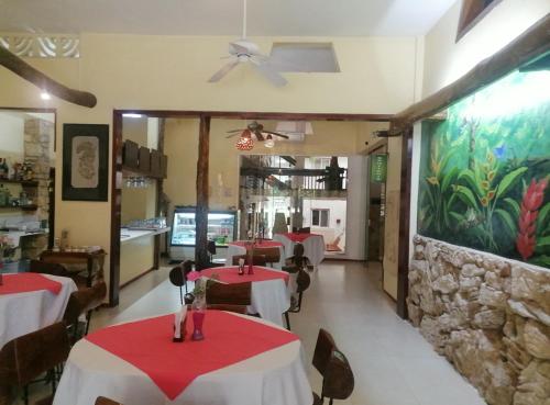 a restaurant with tables and chairs and a stone wall at Hotel - Museo Xibalba in Palenque