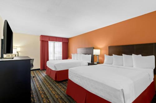 a hotel room with two beds and a flat screen tv at Best Western Kenosha Inn in Broken Arrow