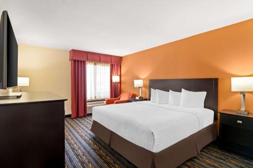 a hotel room with a bed and a flat screen tv at Best Western Kenosha Inn in Broken Arrow