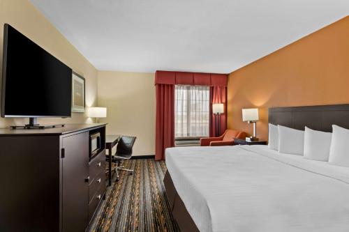 a hotel room with a large bed and a flat screen tv at Best Western Kenosha Inn in Broken Arrow