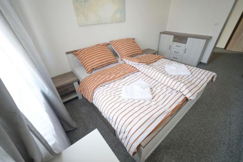 a bedroom with a bed with orange and white sheets at Penzion a restaurace U Jágrů in Kladno