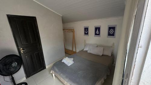 a small room with a bed and a fan at Hospedagem do Iago in Cabo Frio