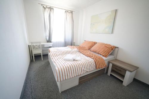 a bedroom with a bed and a table and a window at Penzion a restaurace U Jágrů in Kladno