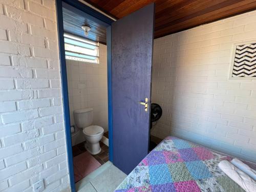 a room with a bed and a bathroom with a toilet at Hospedagem do Iago in Cabo Frio