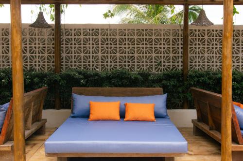 an outdoor bed with two orange pillows on a patio at Café Jeri Hotel - Adults Only in Jericoacoara