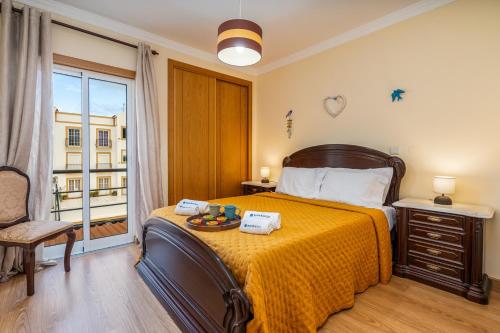 a bedroom with a large bed with a yellow blanket at Bright & Spacious Flat by HostWise in Vila Real de Santo António
