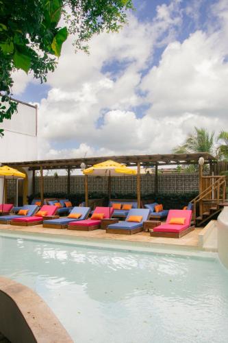 a swimming pool with lounge chairs and umbrellas at Café Jeri Hotel - Adults Only in Jericoacoara