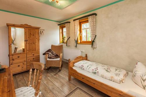 ein Schlafzimmer mit einem Bett und einer Kommode in einem Zimmer in der Unterkunft Pension Bernhardt in Schwarzenberg/Erzgebirge