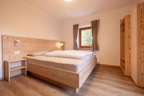 a bedroom with a bed and a window at SAN PIETRO DOLOMITI Small Budget Hotel in Ortisei