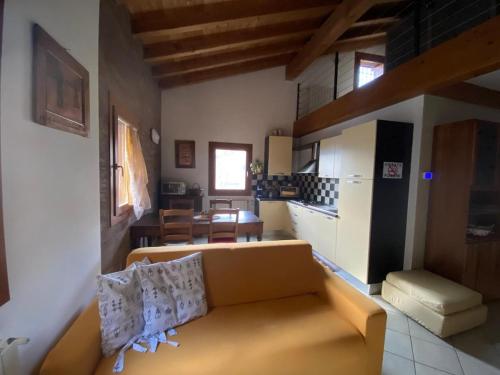 a living room with a couch and a kitchen at Le Rive nel bosco in Capo di Ponte