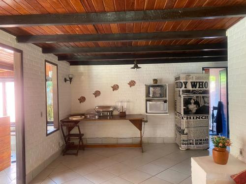 a kitchen with a counter and a table in a room at Hospedagem do Iago in Cabo Frio