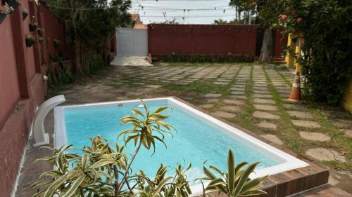 a small swimming pool in a yard with plants at Hospedagem do Iago in Cabo Frio