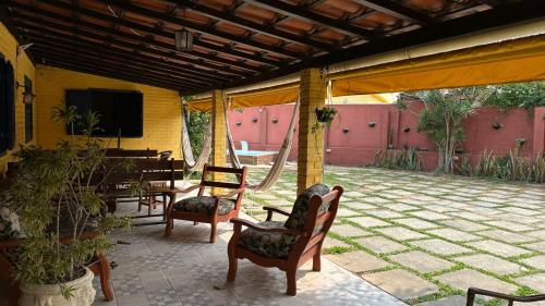 a patio with chairs and a table and a television at Hospedagem do Iago in Cabo Frio