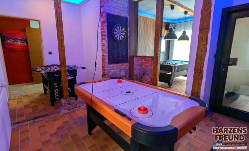 a ping pong table in a room with a pool table at Arode Ferienhaus Harzensfreund in Sankt Andreasberg