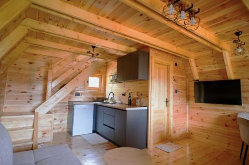 a kitchen in a log cabin with a flat screen tv at Vista Verde in Žabljak