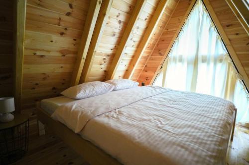 a bed in a wooden room with a window at Vista Verde in Žabljak