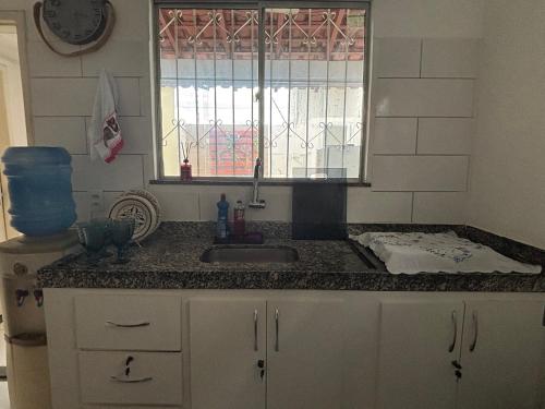 a kitchen counter with a sink and a window at Bragança -Pa linda casa completa in Bragança