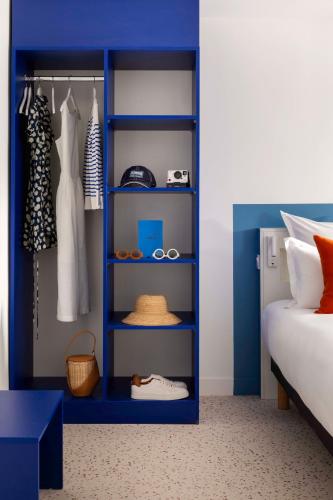 a blue shelf in a bedroom with a bed at Seb & Co in Paris