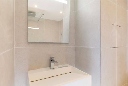 a white bathroom with a sink and a mirror at Seb & Co in Paris