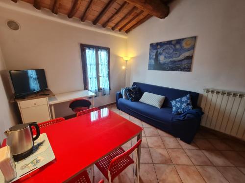 sala de estar con sofá azul y mesa roja en Exploring tuscany, en Chiesina Uzzanese