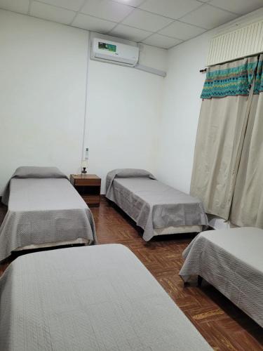 a hospital room with three beds and a window at Casona Villa General Savio in Villa General Savio