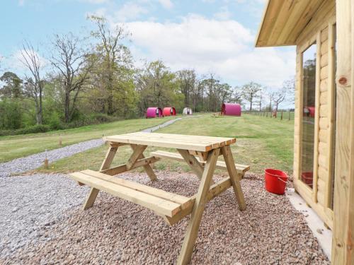 a wooden picnic table sitting next to a building at Pod 1 in St Asaph