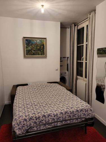 une chambre avec un lit et un tableau au mur dans l'établissement Studio calme proche Montmartre et Batignolles - Metro 13 et 14, à Paris