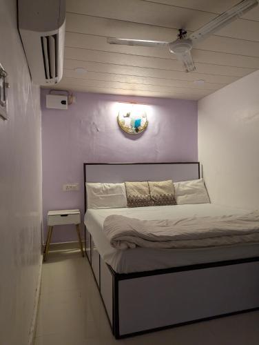a bed in a room with a purple wall at Meenakshi Guest House in Varanasi