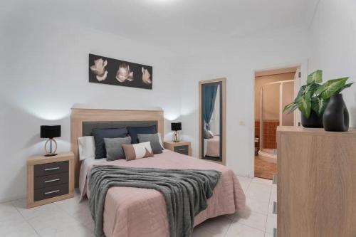 a bedroom with a large bed with a pink blanket at Apartamento Bonjour in Tenerife