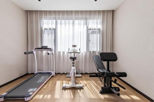 a room with a gym with a treadmill and two chairs at Chengdu Dafang Hotel 大方酒店 in Chengdu