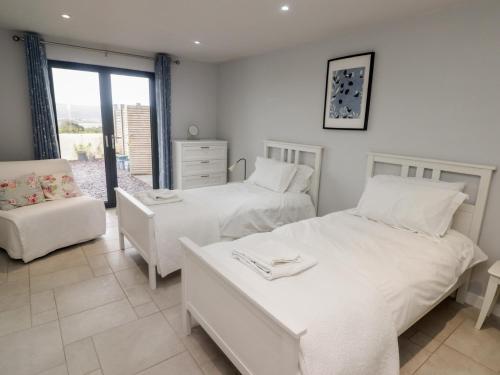 Un dormitorio con dos camas y una silla. en The Willows, en Newport