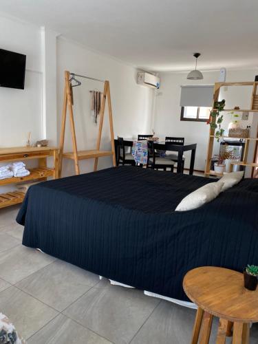 Un dormitorio con una cama grande con una manta azul. en Departamento monoambiente Barrio Martin, en Rosario