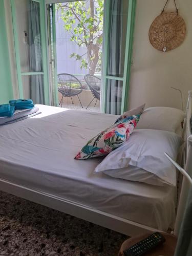 a bed with two pillows and a window in a room at Vitamin sea Apartment 4, Άνετο διαμέρισμα. in Almiropótamos