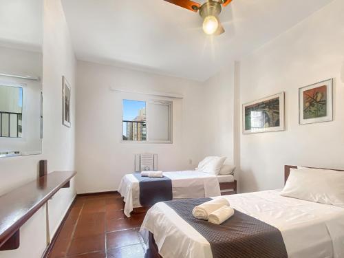 a bedroom with two beds and a ceiling fan at 4 Bedrooms AC Pitangueiras Sea View in Guarujá