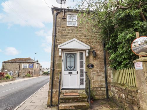 a brick house with a white door on a street at Edendale in Longframlington