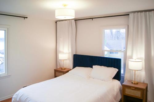 a bedroom with a white bed and two lamps at Waterfront Eagle Lake Home with Yard and Deck in Maple Grove