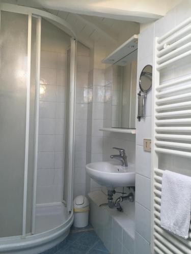 a white bathroom with a sink and a shower at B&B Tra Mare e Laguna in Venice-Lido