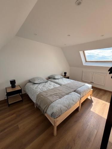 Un dormitorio con una cama grande con una ventana grande. en Bianca, en Caen