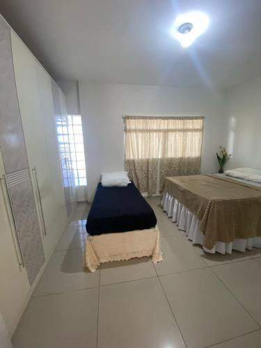 a room with two beds and a window in it at Casa privada 3 quartos ótima localização in Piranhas
