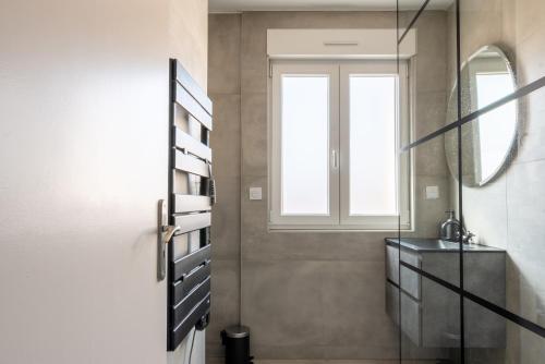 une salle de bain avec un lavabo et un miroir dans l'établissement Le Parisien d'Alsace, à Colmar