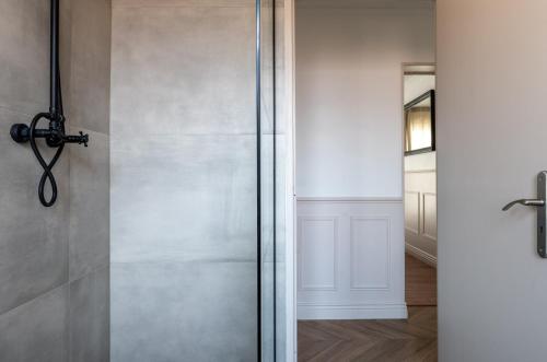 une douche avec une porte vitrée dans une salle de bain dans l'établissement Le Parisien d'Alsace, à Colmar