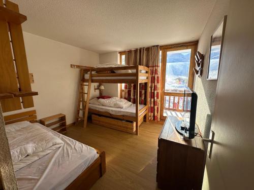 - une chambre avec 2 lits superposés et un bureau avec une télévision dans l'établissement Appartement station de ski la plagne, à La Plagne Tarentaise