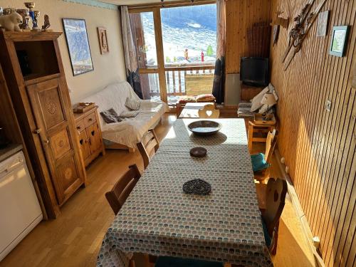 un salon avec une table et un canapé dans l'établissement Appartement station de ski la plagne, à La Plagne Tarentaise