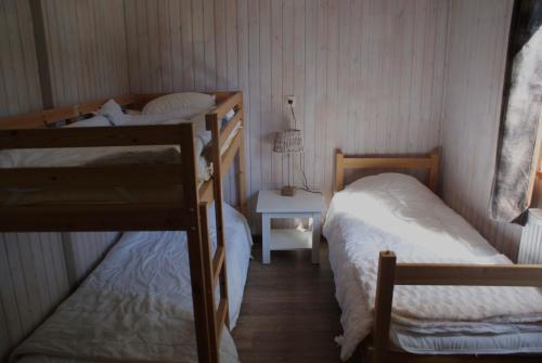 a bedroom with two bunk beds and a table with a lamp at Chalet le Faye in Waimes