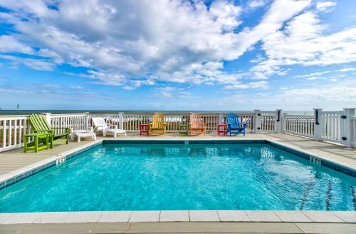 a swimming pool on a balcony with chairs and tables at Dolphin Run by Carolina Beach Realty in Kure Beach