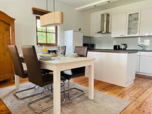 a white kitchen with a table and chairs in a room at Ferienhaus am Tor zur Wachau in Eggendorf