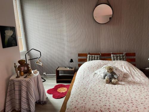 une chambre avec un ours en peluche assis sur un lit dans l'établissement Agréable maison de ville, à LʼAigle