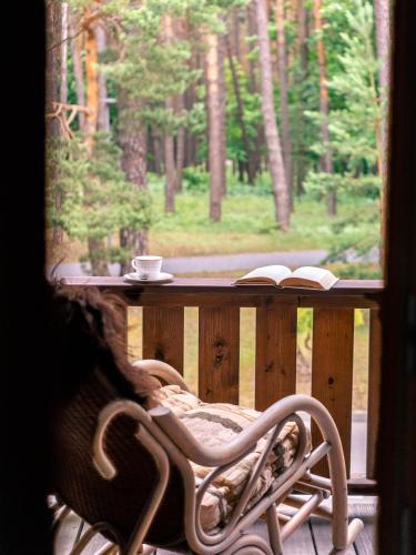 a bench on a porch with a table and a book at Domus Revado in Birštonas